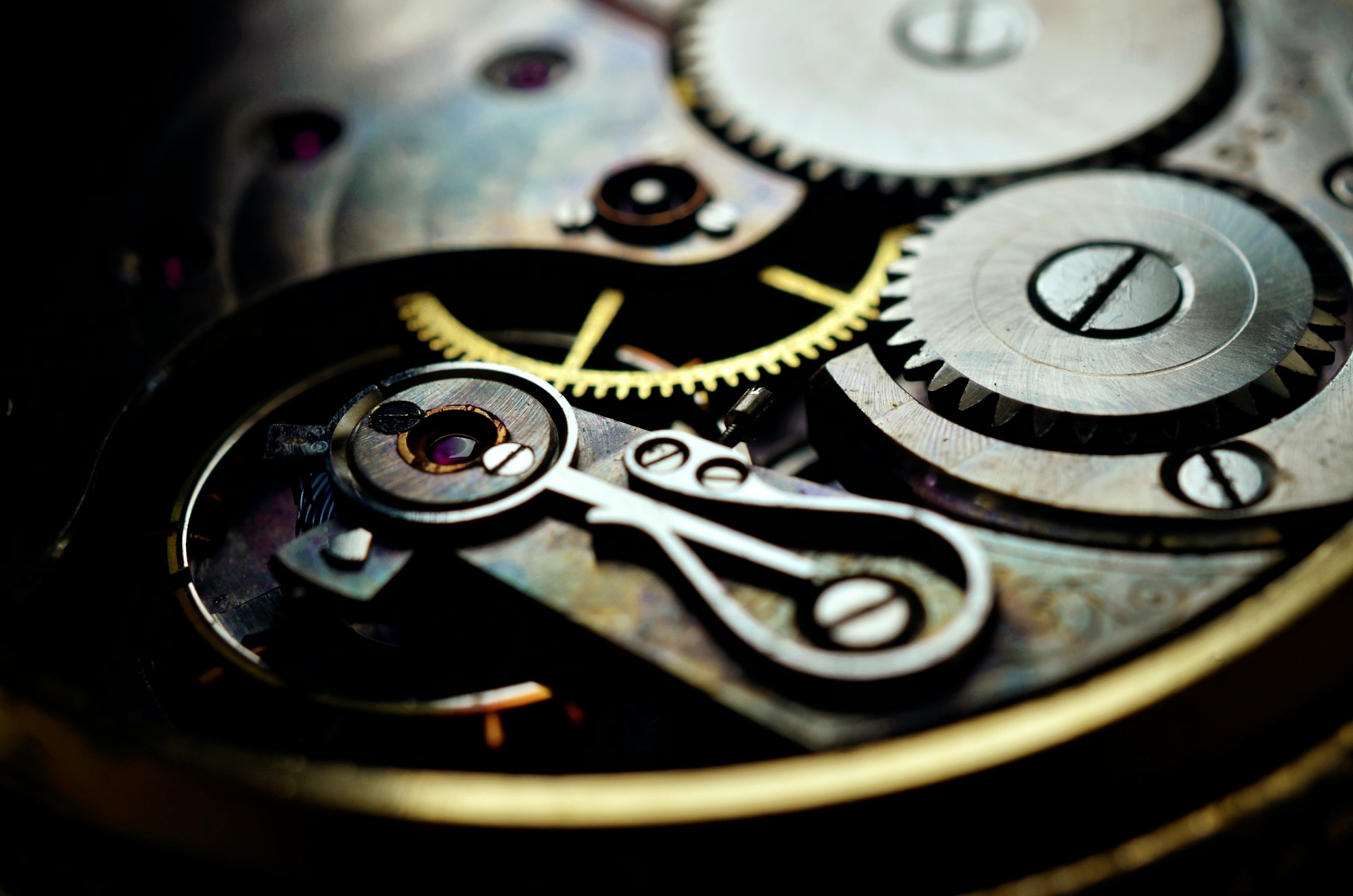 Macro close-up of a watch movement showing interlocking gears and jewel bearings