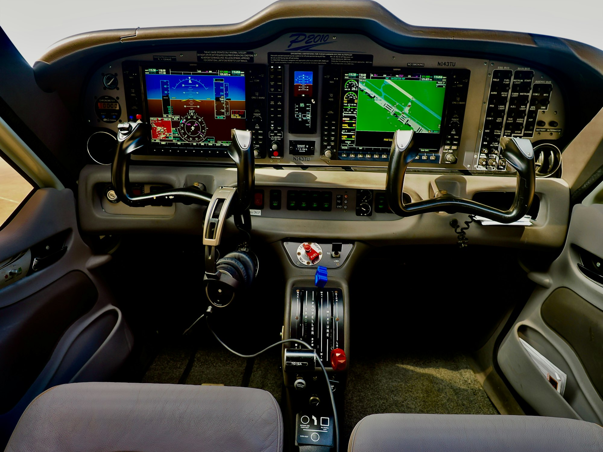 A modern glass cockpit with digital flight displays and organised controls